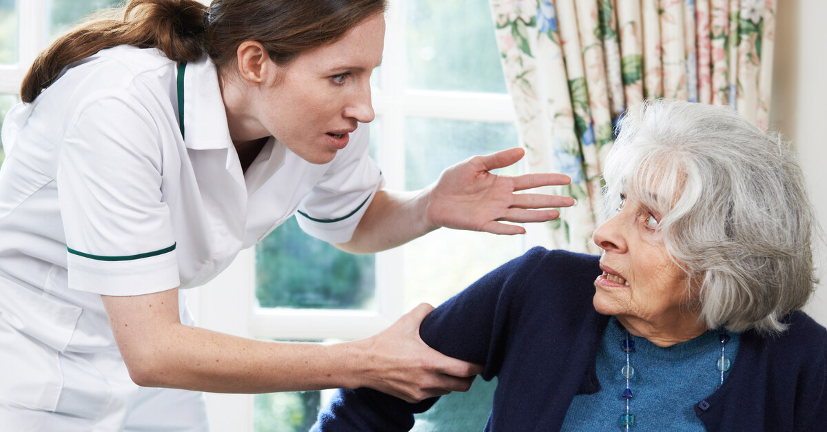 A young woman grabbing an older woman by the arm, sticking out her hand as if to yell or smack her.